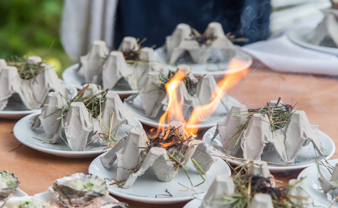 Straw Smoked Sous Vide West Coast Oyster with Spirulina, plated on Rice Hulls